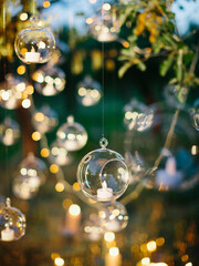 Hanging glass balls with candles inside. Outdoor wedding decor.