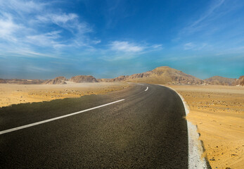 Road in the desert, Empty road. , Travel Highway through the Sahara showing the texture of asphalt sand street, mountain, and hills landscape with dust skyline on a sunny summer day in the background