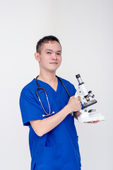 Portrait of a young and bubbly medical student, nurse, intern holding a microscope. Isolated on a...