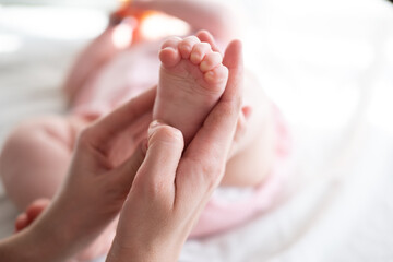Obraz na płótnie Canvas Little baby feet in mother's hands 