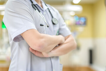 The doctor is standing with his arms crossed waiting for a diagnosis and treatment of a patient.