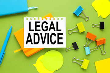 Legal Advice white paper with text on orange notepad near scattered stationery