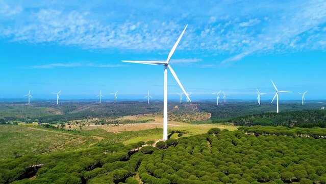 AERIAL 4K - Birds eye view on Wind Power, Turbine, Windmill, Energy Production, Beautiful white windmill on blue sky background 