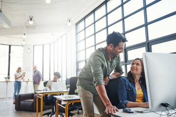 Passion is key to keeping a business strategy moving. a male designer assisting his colleague at...