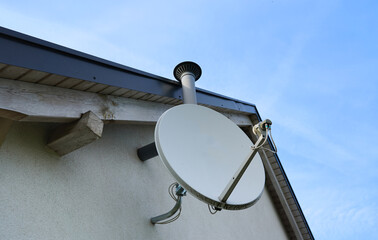 Satellite dish on the roof. Dish aerial installed to the wall. Receiving tv signals. Tv and...