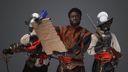 Shot of three conquistadors explorers with map and flintlock guns.