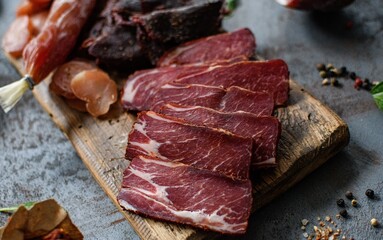 sliced ​​pieces of meat on a dark background. on the wooden cutting board. Top view