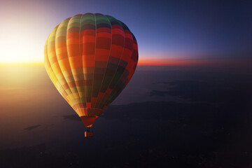 Hot air balloon travel and flies in the evening sky at sunset. Romantic trip on a hot air balloon at dawn