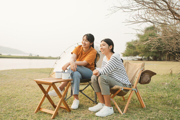 Asian teen group woman while sitting talking enjoyment together at campsite outdoor.