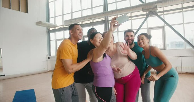 Hugging group of fellows makes selfies grimacing on phone