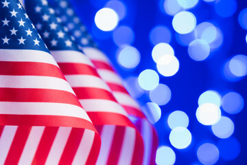 United States flags in a row over bokeh lights background with copy space 