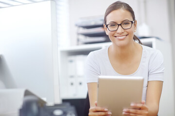 The smile of success. Portrait of an attractive young businesswoman using a digital tablet during work.