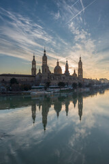 del Pilar basilica, one of the important architectural symbols of zaragoza, and the Ebro river and its reflection with sunset colors and clouds
