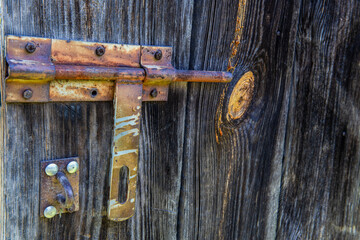stara zardzewiała zasuwa na drewnianych drzwiach stodoły - obrazy, fototapety, plakaty