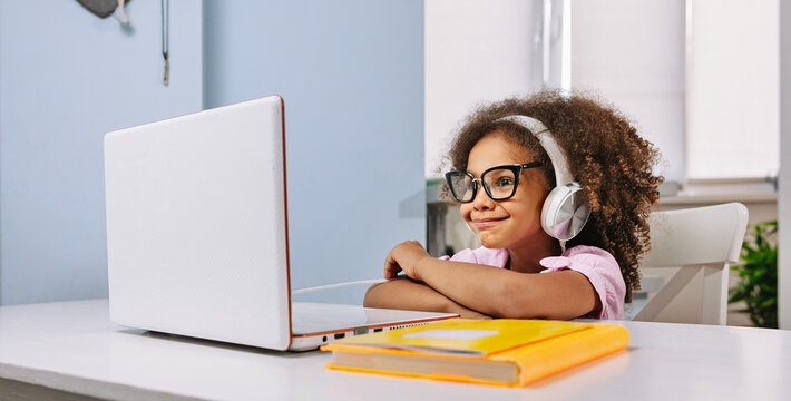 A Black African American student works on a laptop and communicates via video conference