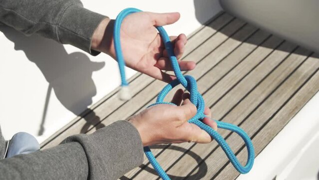 Sailor ties a sea knot close-up. Side view. Tight knot. Bowline. Mooring knot. 4К
