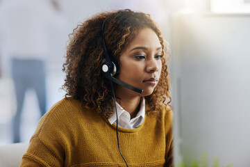Working swiftly to resolve all inquiries. a female agent working in a call centre.