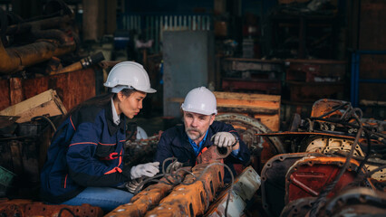 Fototapeta na wymiar Engineer are working in the factory. Worker helping to repair and inspect the machine's readiness. Mechanical technicians are maintaining the engine that is malfunctioning.