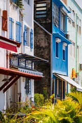 Fototapeta na wymiar Colorful facades of houses on the waterfront of Saint Pierre on tropical island Martinique (France, Lesser Antilles). Idyllic atmosphere near harbour, market and pier of the small touristical village.