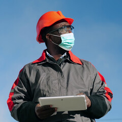 African american workman holds in hands white tablet computer