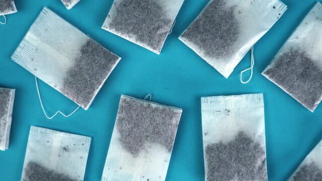 Camera rises up above delicious tea bags lying on light blue