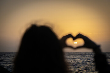 Female hands heart shape on nature bokeh sea sunset, tropical sunset beach. Copy space of happy love travel and freedom in nature concept.  .