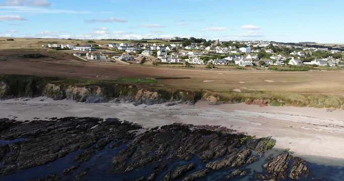Aerial View Of Empty Beach With Striation Rocks At Low Tide With Thurlestone Village In Background. Pan Right