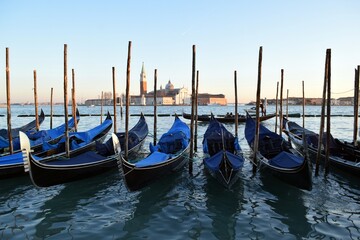 Fototapeta na wymiar Gondolas standing on the pier in the Italian city of Venice