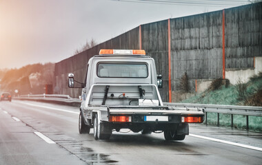 Empty flatbed tow carrier truck. empty car carrier and flatbed tow truck vehicle travelling on a...