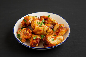 Homemade Grilled Chicken Wings with Parsley on a Plate, side view.