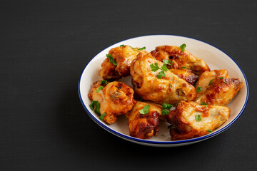 Homemade Grilled Chicken Wings with Parsley on a Plate, side view. Copy space.