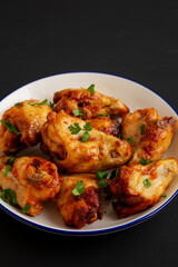Homemade Grilled Chicken Wings with Parsley on a Plate, side view.