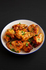Homemade Grilled Chicken Wings with Parsley on a Plate, side view.