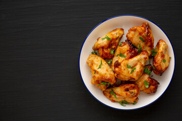 Homemade Grilled Chicken Wings with Parsley on a Plate, top view. Space for text.