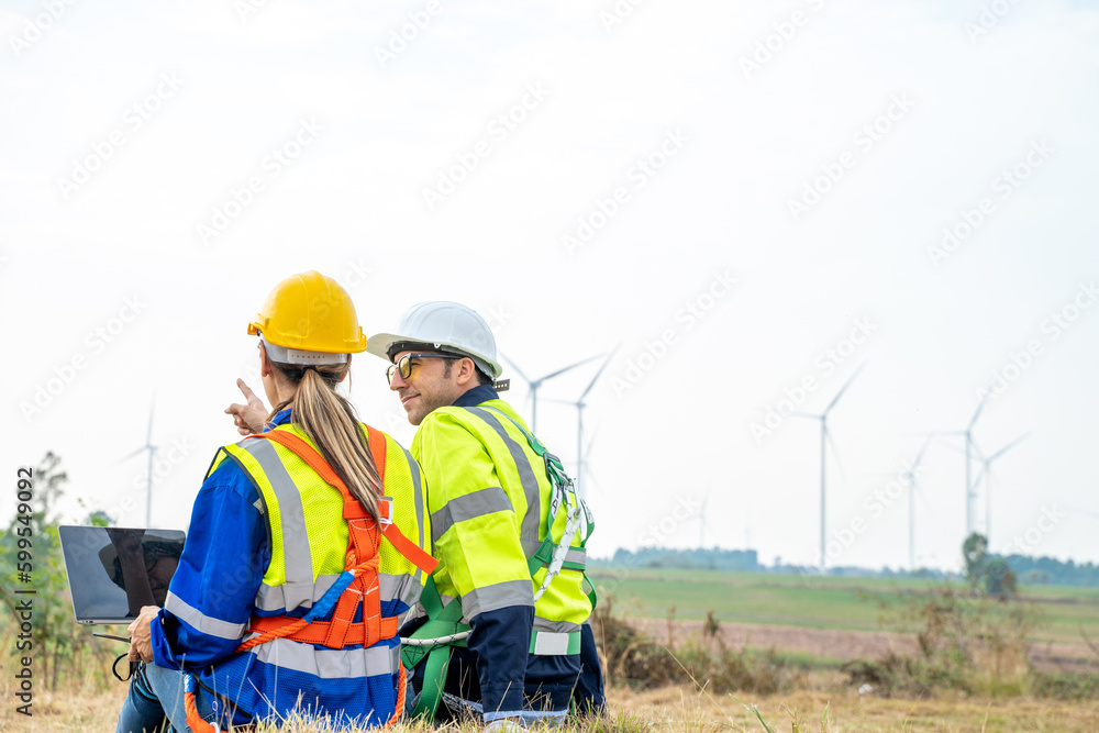 Poster engineer with technician are inspection work in wind turbine farms rotation to generate electricity 