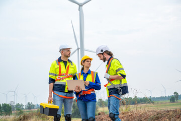 Group of engineers are working with a blueprint in wind turbine farm,Wind power station,Renewable and clean energy concept.