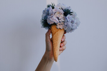 Ice cream cone with light violet flowers  - 599551663
