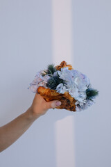 Unrecognizable woman holding croissant with flowers inside - big copy space 