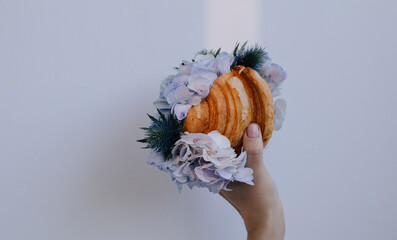 Beautiful croissant with different fresh flowers indoors shot  - 599552042