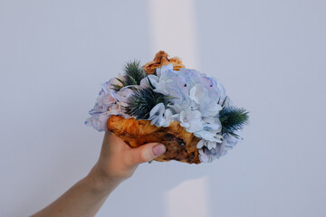 Anonymous woman holding croissant with light violet flowers  - 599552086