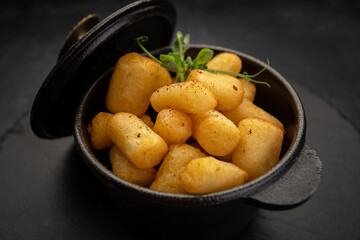 golden brown nuggets in a cast-iron dish on a stone