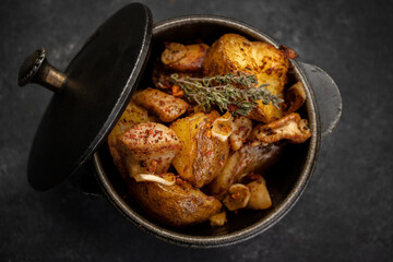 Fried potatoes with garlic and spices in a small cast-iron pot