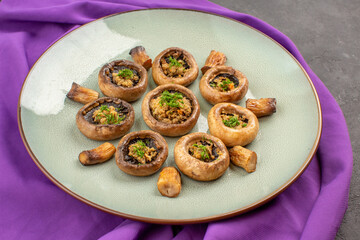 front view cooked mushrooms inside plate on a purple tissue dish meal mushrooms dinner cooking