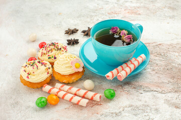 front view cup of tea with candies and cakes on white desk tea dessert biscuit cake pie