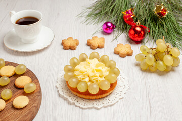 front view cup of tea with cream cake and grapes on white desk fruit tea dessert cream biscuit cake