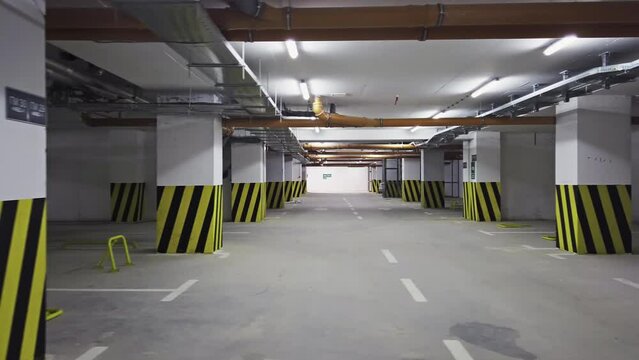 Empty shopping mall underground parking lot or garage interior with concrete stripe painted columns