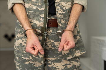 Handcuffed soldier, arrested male army officer in dark prison cell