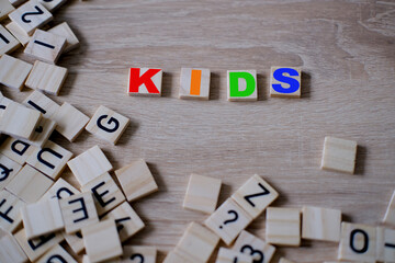close-up square wooden alphabet blocks, KIDS word on wooden table, concept happy childhood, early...