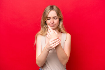 Young English woman isolated on red background suffering from pain in hands
