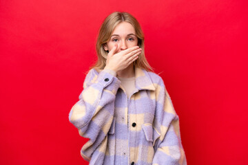 Young English woman isolated on red background covering mouth with hand
